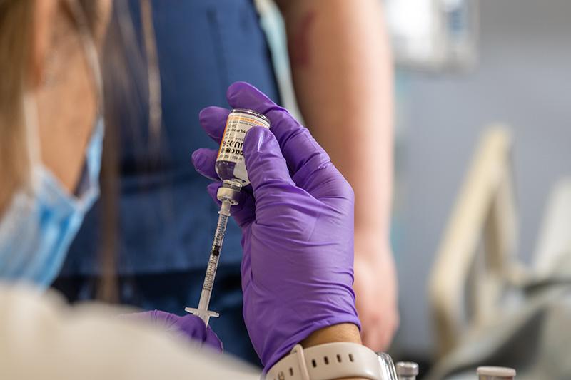 Nurse draws medication from a vial